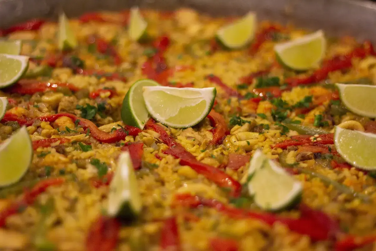 Traditional Spanish paella garnished with lime slices