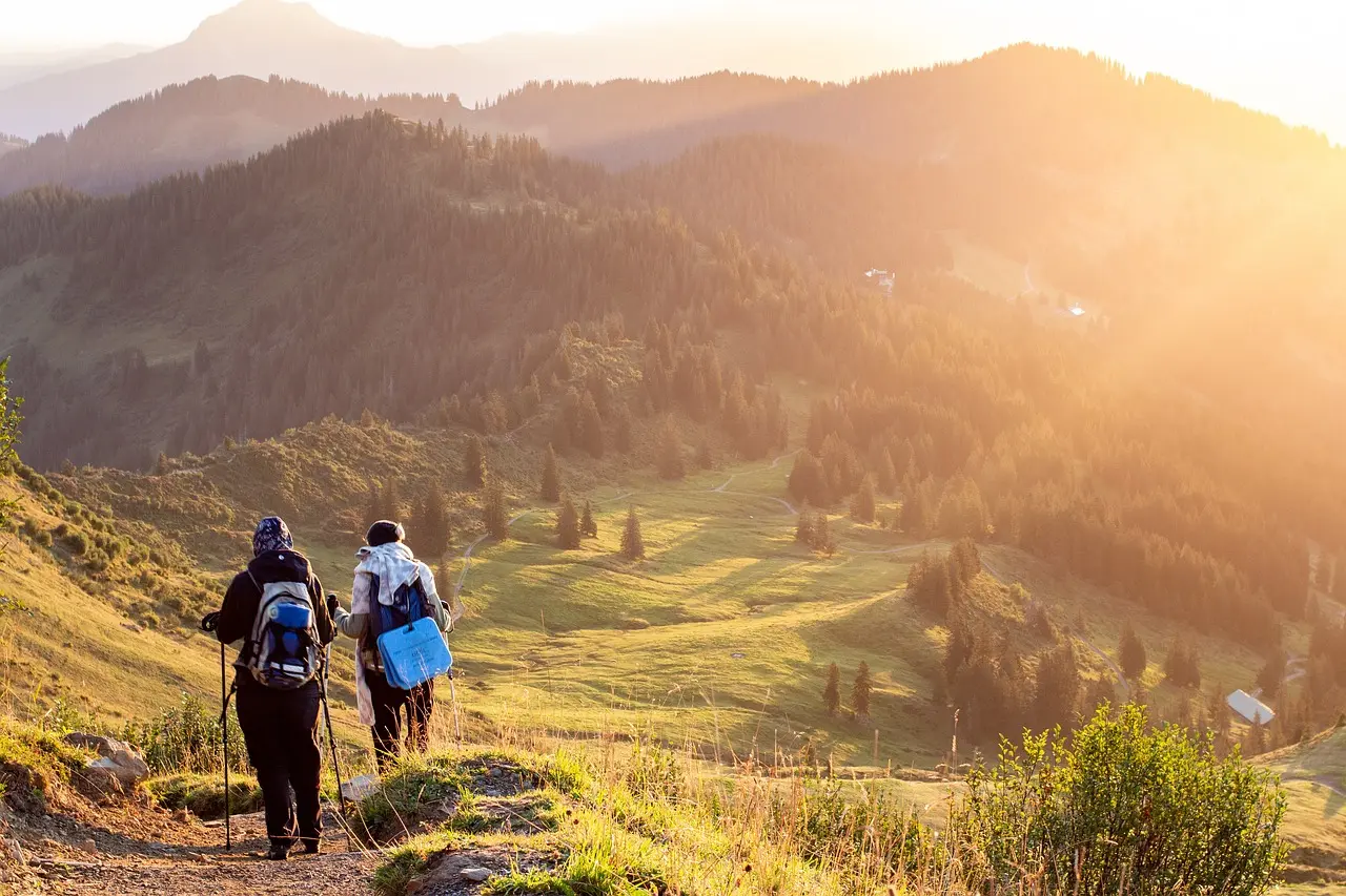 Hikers enjoying a sunrise view of Bosnia's rolling hills and lush valleys.