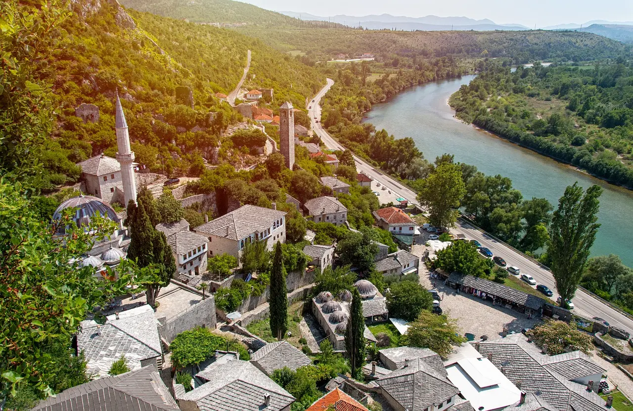 Aerial view of a historic Bosnian village near a winding river.